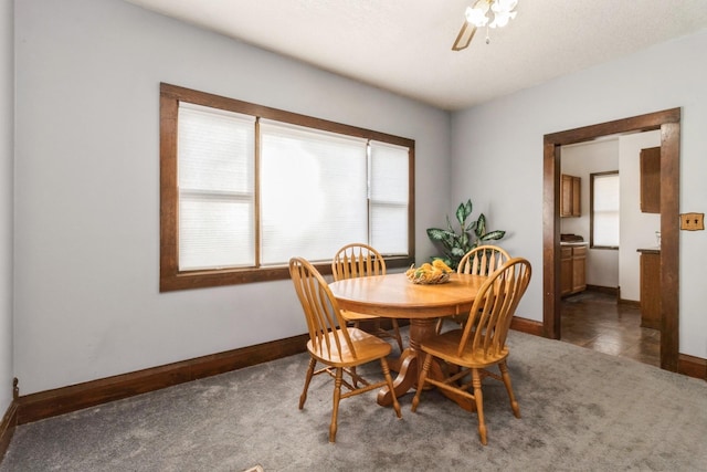 dining room featuring carpet floors, baseboards, and a ceiling fan