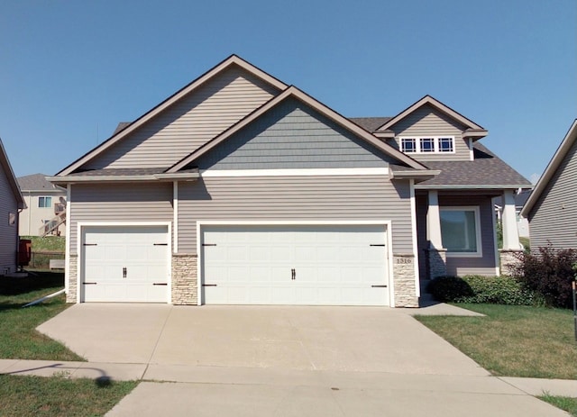 craftsman-style home featuring a front lawn and a garage