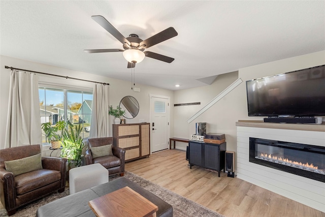 living room featuring light hardwood / wood-style flooring and ceiling fan