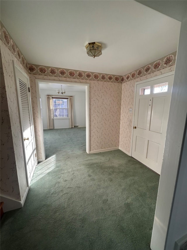 foyer entrance with carpet floors and a notable chandelier