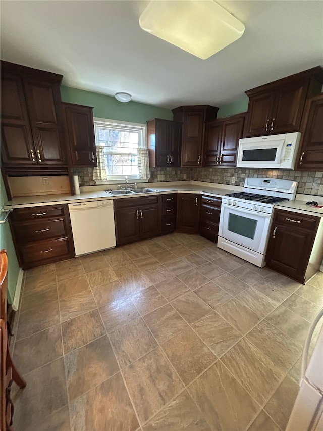 kitchen featuring decorative backsplash, dark brown cabinets, a sink, light countertops, and white appliances