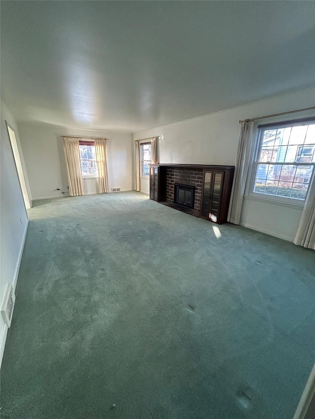 unfurnished living room featuring visible vents, carpet, baseboards, and a fireplace