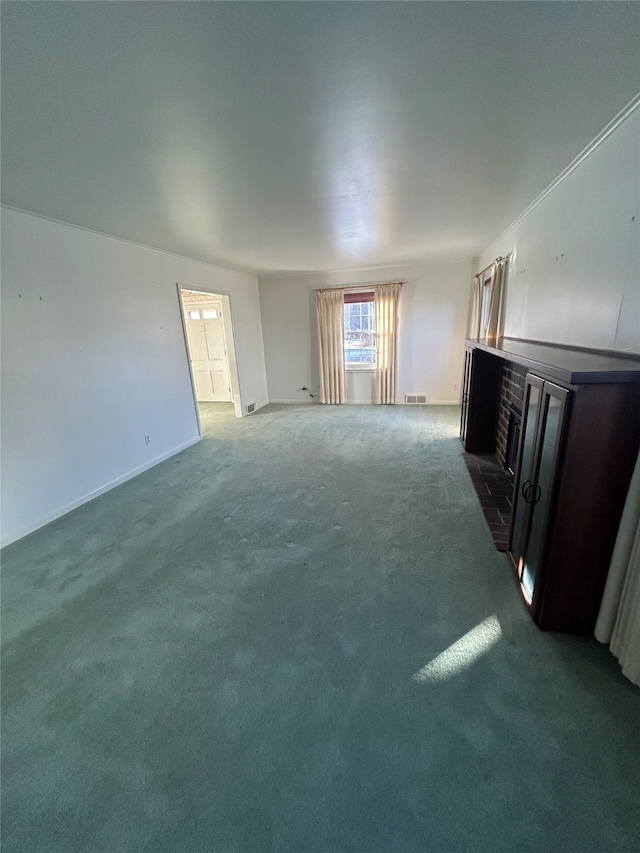 unfurnished living room with dark carpet and a brick fireplace