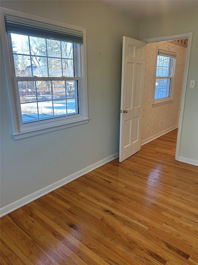 empty room with baseboards and wood finished floors