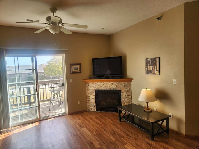 living room with a fireplace, wood-type flooring, vaulted ceiling, a textured ceiling, and ceiling fan