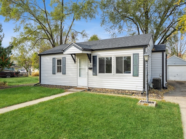 view of front of home featuring a front yard, an outdoor structure, a garage, and cooling unit