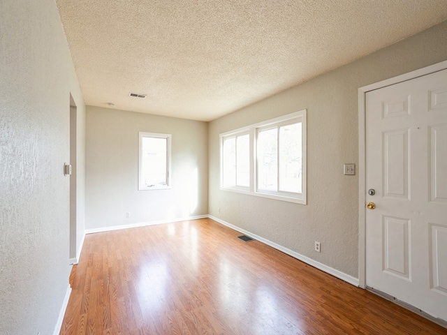 unfurnished room featuring a textured ceiling and wood-type flooring