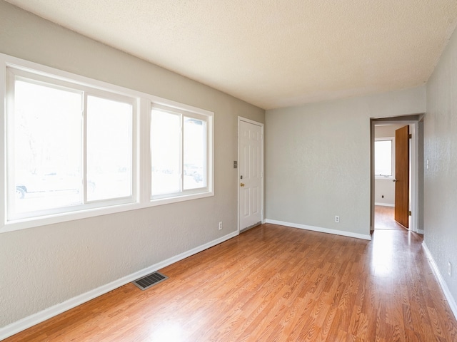 empty room featuring light hardwood / wood-style flooring and a textured ceiling