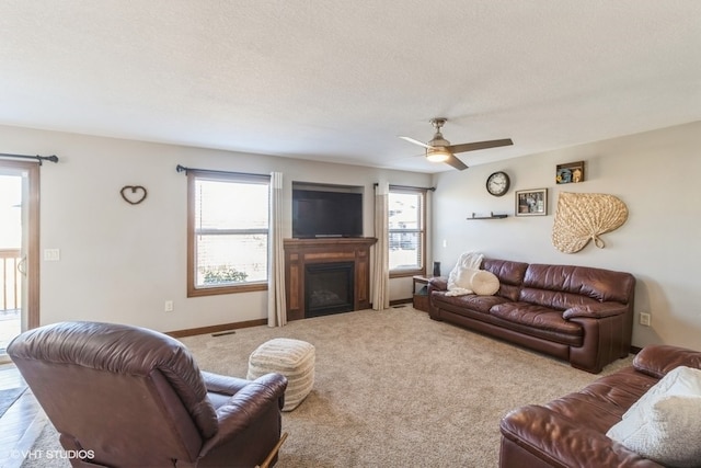 living room with ceiling fan, carpet, and a textured ceiling