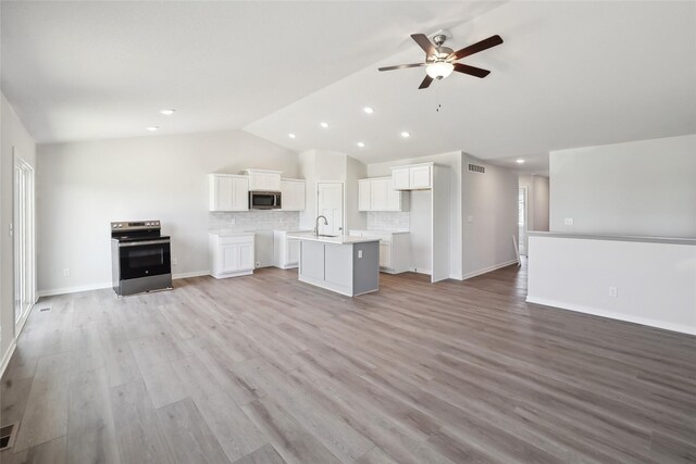 732 NE Deerfield Dr, Ankeny, IA 50021 - unfurnished living room featuring a sink, lofted ceiling, a ceiling fan, recessed lighting, and light wood finished floors