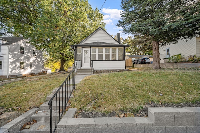 view of front of house featuring a front lawn and a sunroom