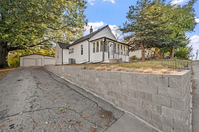 view of front of home featuring cooling unit, an outdoor structure, and a garage