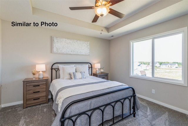 bedroom featuring a tray ceiling, ceiling fan, and dark carpet