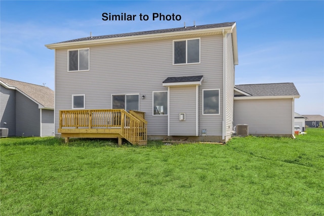 rear view of house featuring central air condition unit, a deck, and a lawn