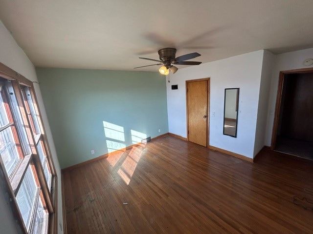 spare room featuring dark wood-type flooring, ceiling fan, vaulted ceiling, and a wealth of natural light