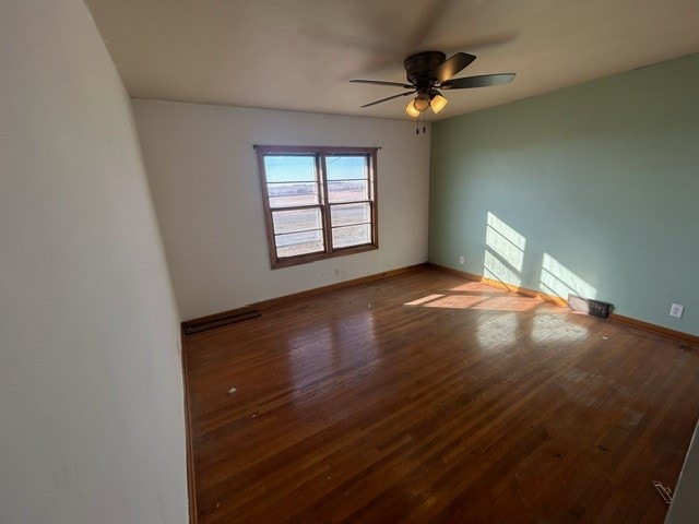 spare room featuring wood-type flooring and ceiling fan