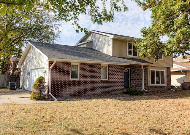 view of front facade featuring a front lawn, central AC unit, and a garage