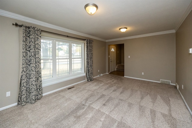 carpeted spare room featuring crown molding