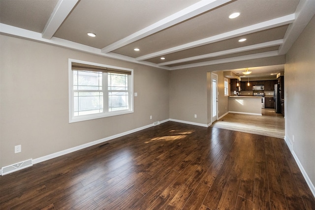 unfurnished living room featuring beamed ceiling and dark hardwood / wood-style flooring