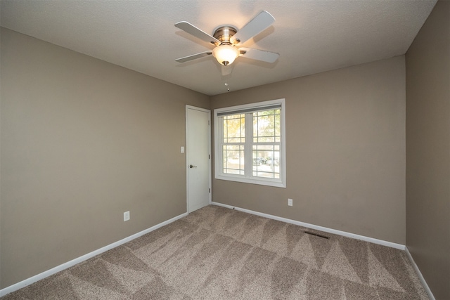 carpeted empty room with a textured ceiling and ceiling fan