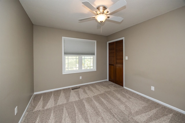 carpeted spare room featuring ceiling fan