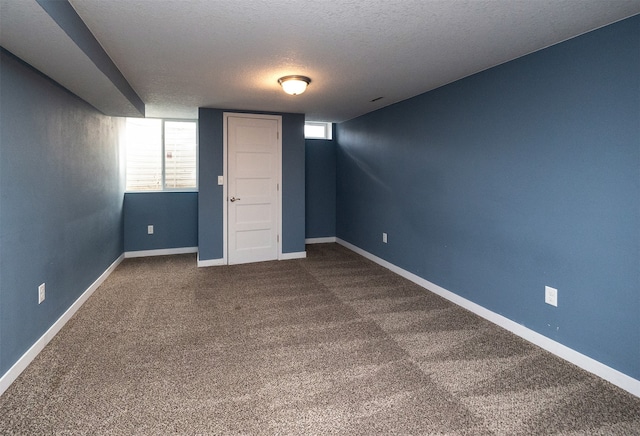 basement featuring a textured ceiling and carpet flooring