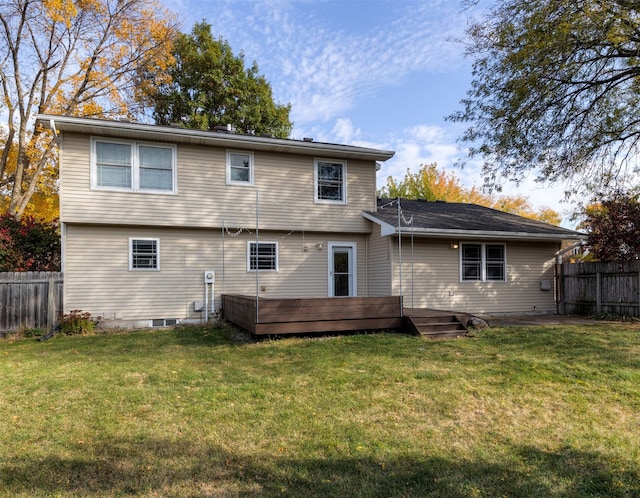 back of property featuring a wooden deck and a lawn