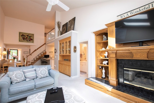 carpeted living room with ceiling fan and a fireplace