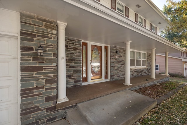 view of exterior entry featuring covered porch