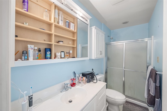 bathroom with vanity, toilet, and a shower with shower door