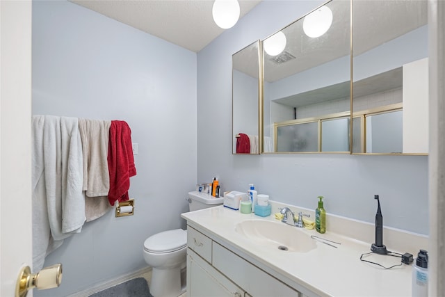 bathroom with vanity, toilet, and walk in shower