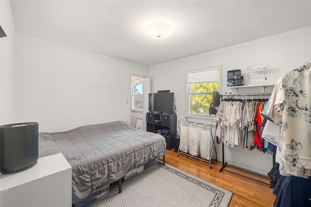 bedroom with hardwood / wood-style floors and a textured ceiling