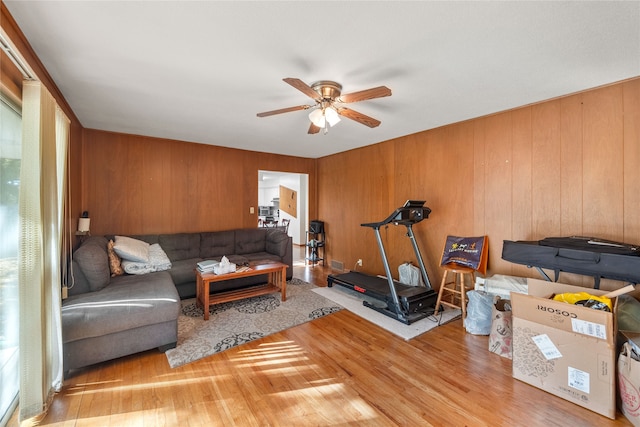 exercise area featuring wood walls, hardwood / wood-style flooring, and ceiling fan