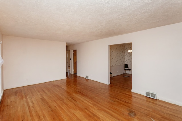 empty room featuring hardwood / wood-style flooring and a textured ceiling