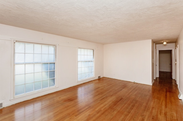 unfurnished room featuring a textured ceiling and wood-type flooring