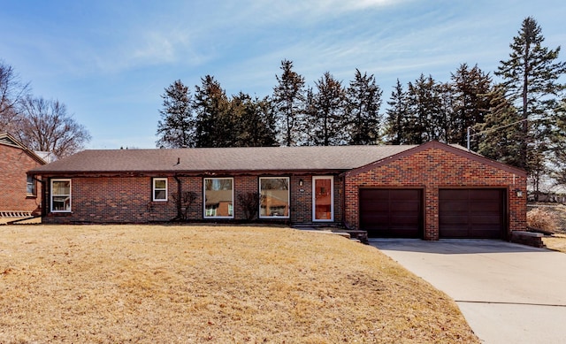 single story home with a front lawn, brick siding, a garage, and driveway