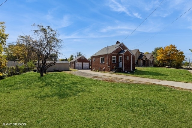 view of front of house featuring an outbuilding, a garage, and a front lawn