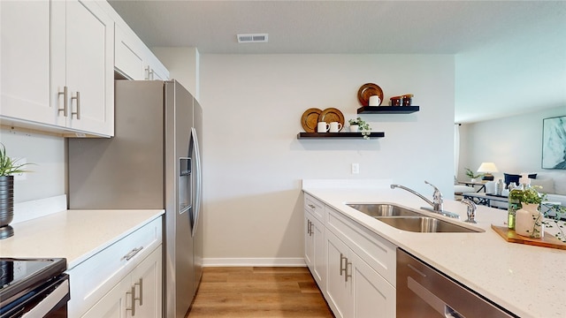 kitchen featuring sink, light hardwood / wood-style floors, white cabinets, and dishwasher