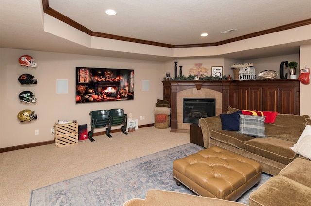 carpeted living room with a raised ceiling, a tile fireplace, and ornamental molding