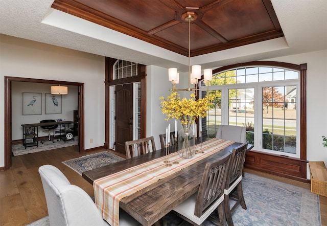 dining area featuring a raised ceiling, crown molding, wooden ceiling, a notable chandelier, and dark hardwood / wood-style floors