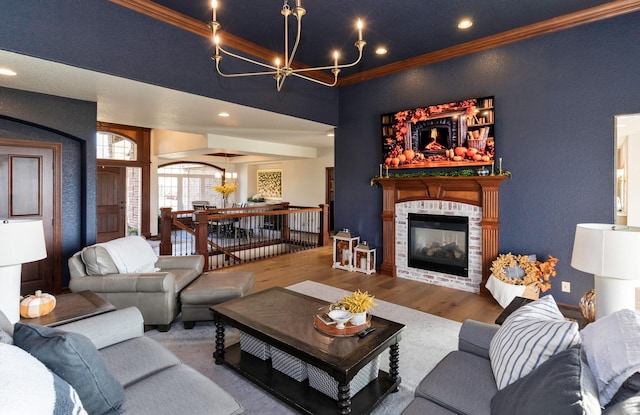 living room featuring ornamental molding, hardwood / wood-style flooring, and a notable chandelier