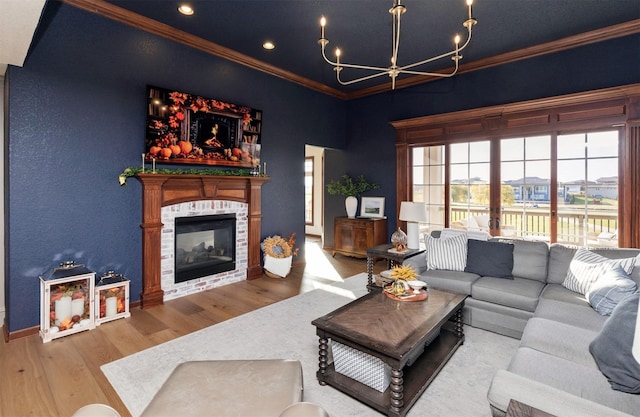 living room with crown molding, a multi sided fireplace, light hardwood / wood-style flooring, and an inviting chandelier