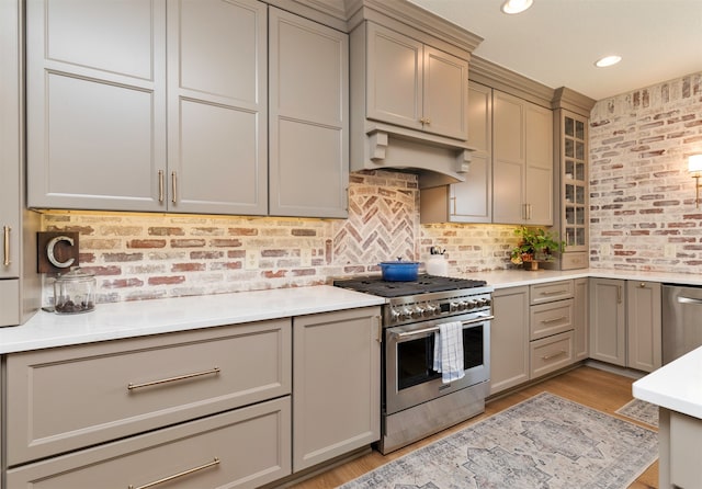 kitchen with gray cabinets, light wood-type flooring, and stainless steel appliances