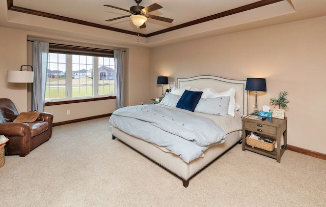 bedroom featuring carpet floors, a raised ceiling, ceiling fan, and ornamental molding