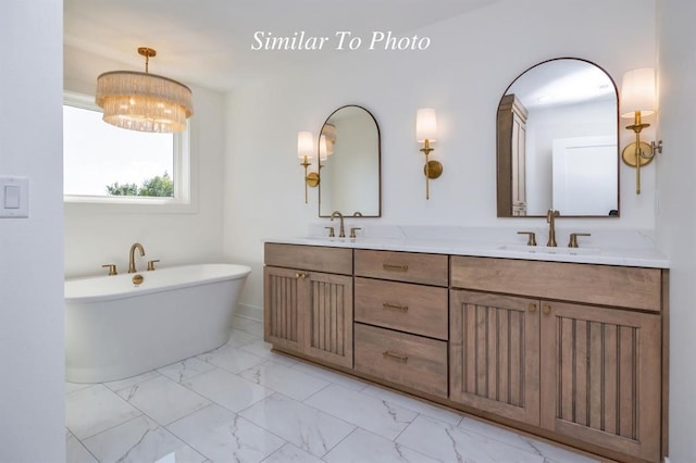 bathroom with vanity, a notable chandelier, and a bathing tub