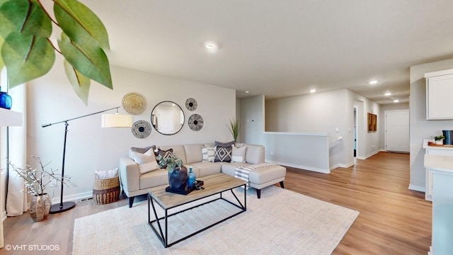 living room with recessed lighting, light wood finished floors, and baseboards