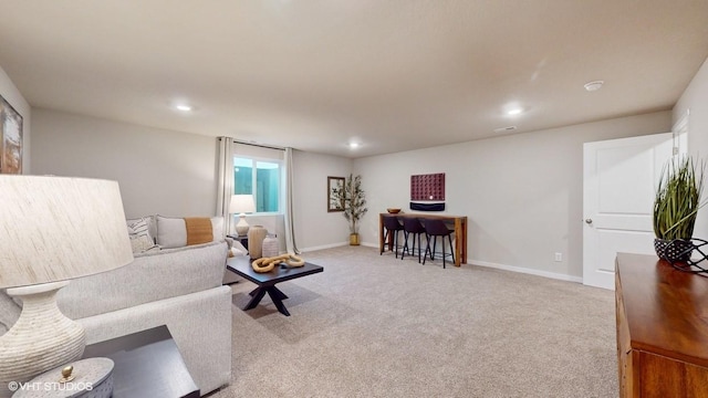living area featuring light colored carpet, recessed lighting, and baseboards