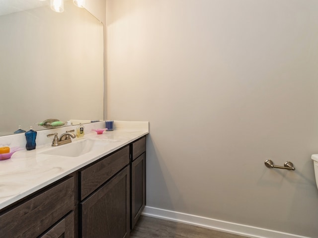 bathroom featuring vanity, hardwood / wood-style floors, and toilet