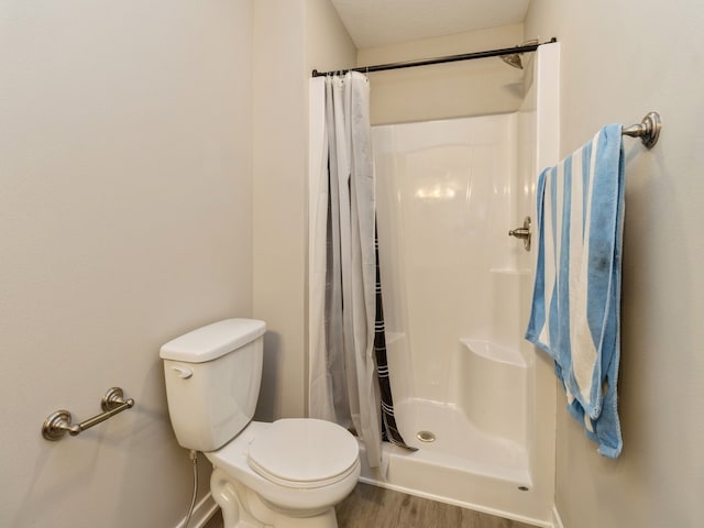 bathroom featuring toilet, hardwood / wood-style floors, and walk in shower