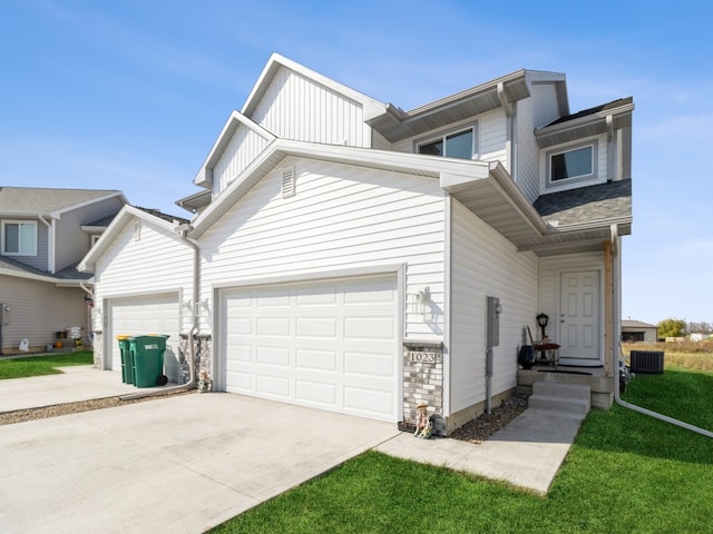 view of front of house with cooling unit, a front yard, and a garage